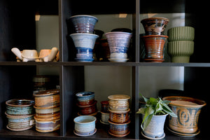 Collection of ceramic pots on a dark wooden shelf